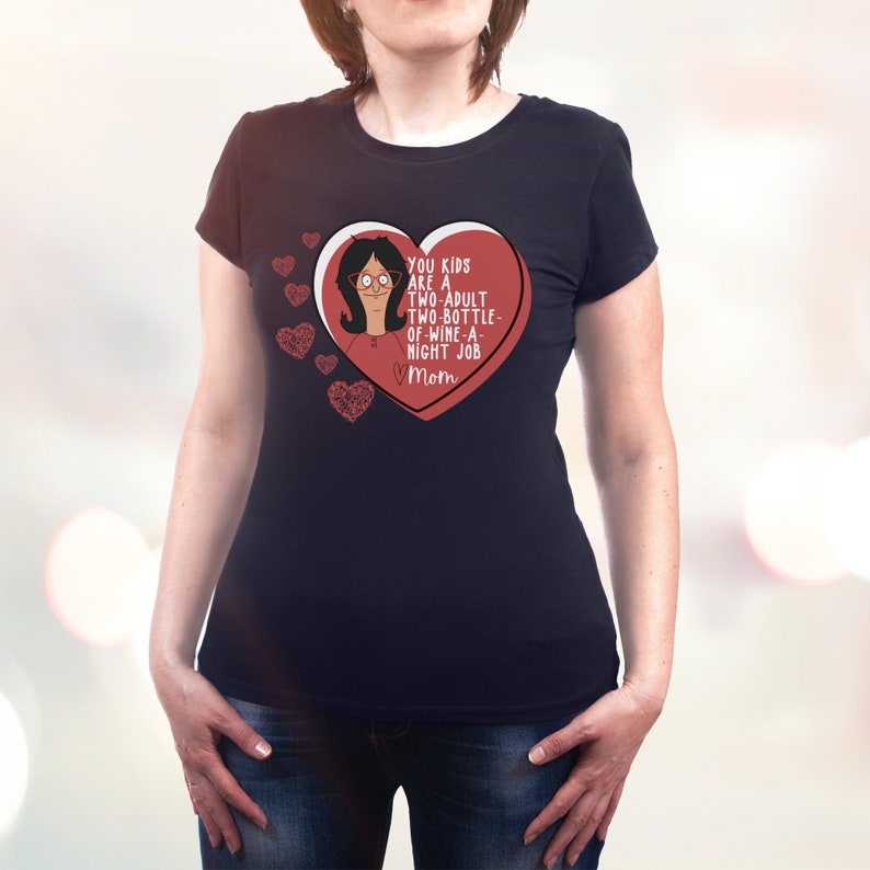 K&ouml;nnte beinhalten: Schwarzes T-Shirt mit rotem Herzdesign. Das Herz enth&auml;lt eine Cartoonfigur und den Text "YOU KIDS ARE A TWO-ADULT TWO-BOTTLE-OF-WINE-A-NIGHT JOB Mom". Mehrere rote Herzen sind ebenfalls vorhanden.