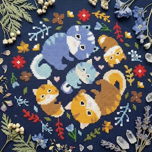 Könnte beinhalten: Ein Kreuzstichmuster mit fünf stilisierten Katzen in Blau-, Braun- und Gelbtönen, die in einem Kreis angeordnet sind. Die Katzen sind von floralen und botanischen Elementen in Rot, Gelb und Grün umgeben, vor einem dunkelblauen Hintergrund.