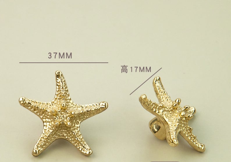 K&ouml;nnte beinhalten: Goldfarbene Schrankkn&ouml;pfe in Form von Seesternen. Die Kn&ouml;pfe sind 3,7 cm breit und 1,7 cm hoch. Die Seesterne haben eine strukturierte Oberfl&auml;che und sind als dekorative Beschl&auml;ge f&uuml;r Schubladen oder Schr&auml;nke konzipiert.