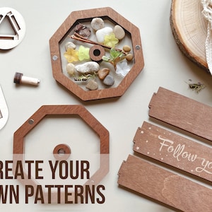 May include: Wooden octagon-shaped frame with a clear window, filled with natural elements like stones, leaves, and twigs.  Two smaller wooden frames with a triangular cutout are also shown. The text "CREATE YOUR OWN PATTERNS" is printed below the octagon frame.