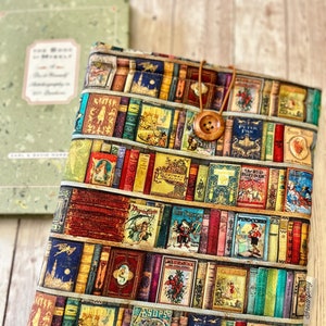Puede incluir: Una funda para libros con un patrón colorido de libros en una estantería. La funda está hecha de tela y tiene un botón marrón y una correa marrón.