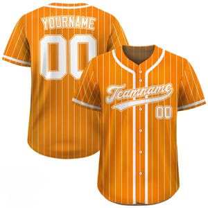 Pode incluir: Camisola de beisebol laranja com riscas brancas, gola e acabamentos das mangas. A camisola apresenta o texto "Teamname" e o n&uacute;mero "00" na frente, e "YOURNAME" e o n&uacute;mero "00" nas costas.