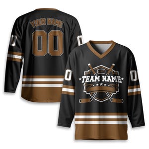 May include: Black hockey jersey with brown and white accents. Features a V-neck, long sleeves, and a design with crossed hockey sticks, a puck, and the text "TEAM NAME". The back displays "YOUR NAME" and the number "00".