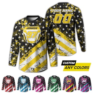 May include: Long-sleeved jersey with a black and yellow American flag design, white stars, and the text "JONASH 97". The back features the text "YOUR NAME" and "00". Additional jerseys in various colours are shown.