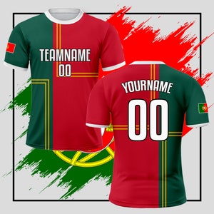 May include: Two red and green soccer jerseys with gold accents. The jerseys have the text "TEAMNAME 00" and "YOURNAME 00" on them. The jerseys are on a background with a red and green brushstroke design.