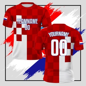 Puede incluir: Camiseta de f&uacute;tbol roja y blanca con un patr&oacute;n a cuadros y la bandera croata en la manga. La camiseta tiene "TEAMNAME 00" en la parte delantera y "YOURNAME 00" en la parte posterior.