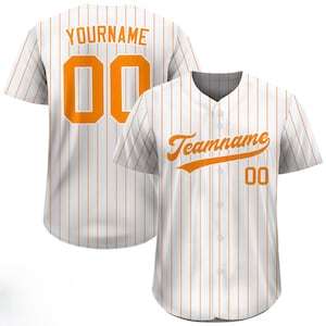 Pode incluir: Camisola de beisebol branca com riscas laranja finas. A frente apresenta a palavra "Teamname" em escrita laranja e o n&uacute;mero "00". A parte de tr&aacute;s exibe "YOURNAME" e o n&uacute;mero "00" em laranja. Um artigo desportivo cl&aacute;ssico.