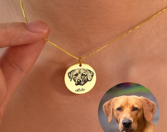 Puede incluir: Collar de oro con un colgante redondo con una imagen grabada en blanco y negro de la cabeza de un perro. El colgante está inscrito con el nombre "Lola".
