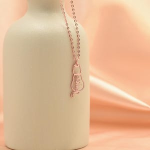 May include: A rose gold necklace with a delicate cat silhouette pendant. The cat's outline is filled with the word "always".