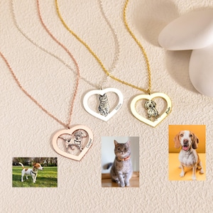 Puede incluir: Tres collares de plata en forma de corazón con retratos de mascotas personalizados y nombres. Los collares están sobre un fondo blanco con una piedra blanca y una piedra amarilla.