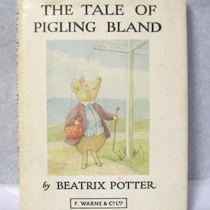 Puede incluir: Una portada de libro vintage con un personaje de cerdo llamado Pigling Bland, ilustrado en un estilo caprichoso. El libro se titula "The Tale of Pigling Bland" y está escrito por Beatrix Potter. La portada es de color crema con texto negro y una ilustración colorida.