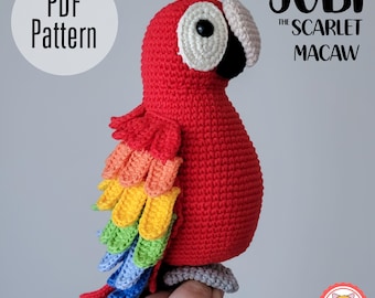 May include: A handmade crochet scarlet macaw bird with vibrant red, yellow, orange, green, and blue feathers. The bird has a white and black eye, a beige beak, and a gray perch. The text "PDF Pattern" and "Jubi the Scarlet Macaw" are visible.