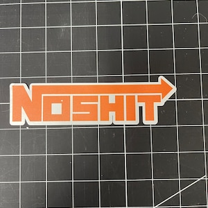Op de afbeelding: Oranje sticker met het woord "NOSHIT" in een vetgedrukte, schreefloze letter, met een pijl naar rechts. De sticker heeft een witte rand en staat op een zwarte rasterachtergrond.