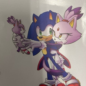 May include: A blue and purple cartoon character with a red and white shoe is holding a purple cartoon character with a red and white shoe. The blue character is holding the purple character in a hug.