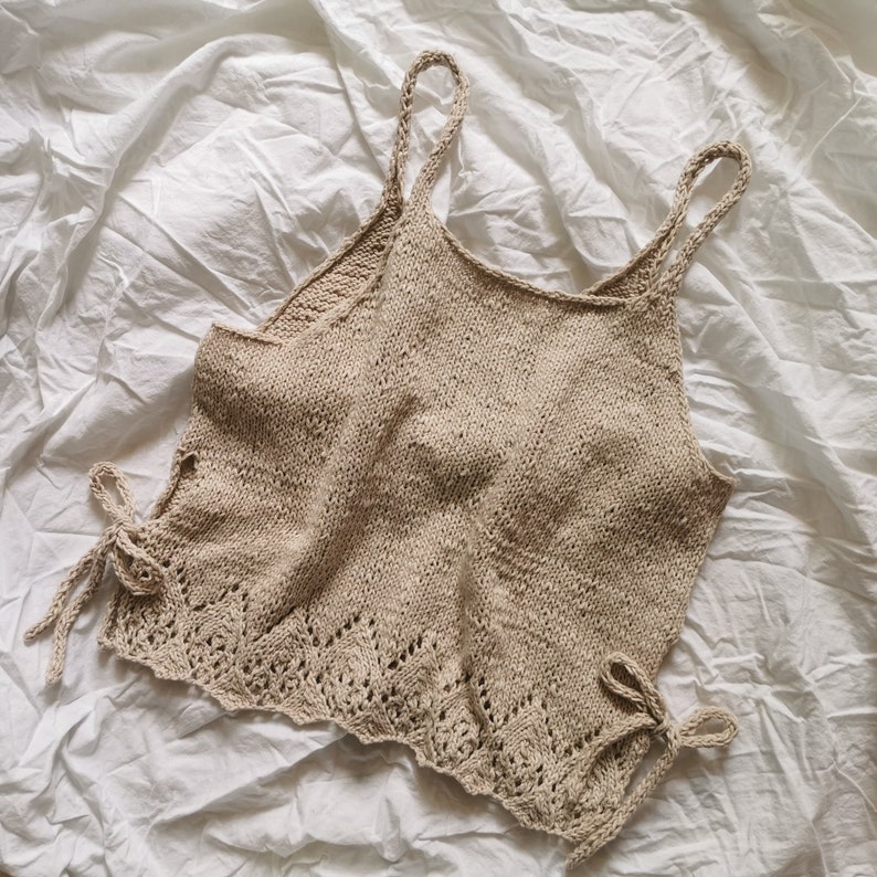 Puede incluir: Un top de tirantes de crochet beige con un delicado borde de encaje y tirantes de lazo. El top est&aacute; hecho de un hilo suave y ligero y tiene un ajuste holgado.