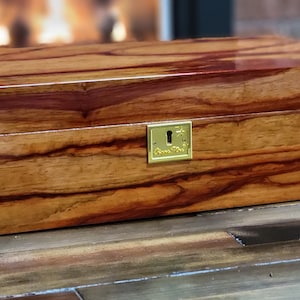 Large humidor will store up to 110 cigars. Made from exotic Padouk wood finished with 15 coats of lacquer. 4 cedar dividers.