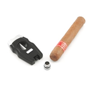 May include: A black and silver cigar cutter with a silver ring and a brown cigar with a red and white band that says "NO.4 HABANA".