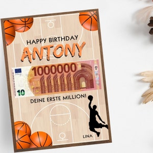 Puede incluir: Una tarjeta de cumplea&ntilde;os con tem&aacute;tica de baloncesto. La tarjeta presenta una cancha de baloncesto con un jugador de baloncesto haciendo un mate. La tarjeta tambi&eacute;n tiene un billete falso de 100.000 euros con el texto "Happy Birthday Antony, Deine erste Million!" y "Lina".
