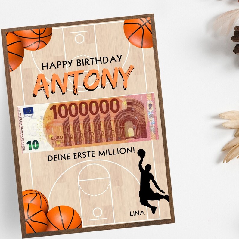 Puede incluir: Una tarjeta de cumplea&ntilde;os con tem&aacute;tica de baloncesto. La tarjeta presenta una cancha de baloncesto con un jugador de baloncesto haciendo un mate. La tarjeta tambi&eacute;n tiene un billete falso de 100.000 euros con el texto "Happy Birthday Antony, Deine erste Million!" y "Lina".