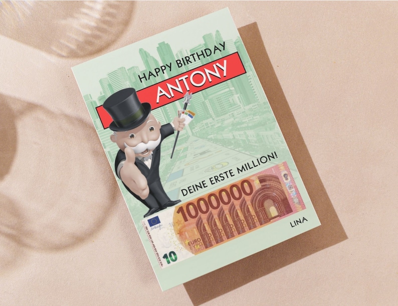May include: A green and white birthday card featuring a cartoon Monopoly Man character with a top hat and a monocle. The card has the text "Happy Birthday Antony" and "Deine erste Million!" with a large euro bill in the bottom right corner. The card is signed "Lina".