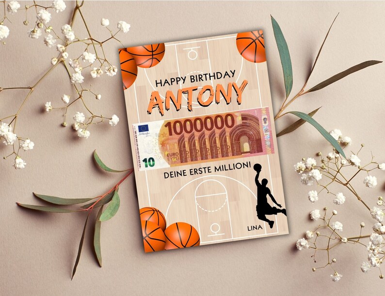 Puede incluir: Una tarjeta de cumplea&ntilde;os con tem&aacute;tica de baloncesto. La tarjeta presenta una cancha de baloncesto con una silueta de jugador de baloncesto, una pelota de baloncesto y un billete falso de 10 euros con el texto "1000000" y "Deine erste Million!" La tarjeta dice "Happy Birthday Antony".