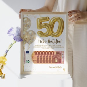 K&ouml;nnte beinhalten: Eine gerahmte Geburtstagskarte mit einer goldenen Ballonnummer 50, Konfetti und einem Euro-Banknoten mit dem Text "Liebe Natalia! Herzlichen Gl&uuml;ckwunsch zum Geburtstag und viel Spass mit deiner ersten Million! 1000000 Sara und Wilhelm"