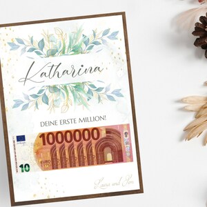 May include: A white card with a green and blue floral design. The card says "Katharina" in cursive and "Deine erste Million!" with a 10 euro bill that says "1000000" on it. The card is signed "Laura and Tom".