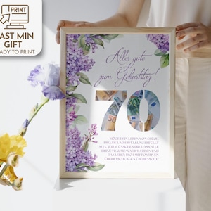 Op de afbeelding: Een ingelijste printbare kaart met een aquarel bloemenontwerp en de tekst "Alles gute zum Geburtstag!" met het nummer 70 in het midden. Het nummer 70 is gemaakt van eurobiljetten.