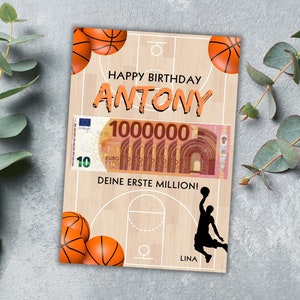 Puede incluir: Una tarjeta de cumplea&ntilde;os con tem&aacute;tica de baloncesto con un dise&ntilde;o de cancha de baloncesto, dos balones de baloncesto y una silueta de un jugador de baloncesto. La tarjeta dice "Happy Birthday Antony" y "Deine erste Million!" que se traduce como "&iexcl;Tu primer mill&oacute;n!"