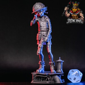 Puede incluir: Una figura en miniatura de plástico gris impresa en 3D que representa a un personaje con un sombrero y sosteniendo un arma de fuego. La figura está de pie sobre una base gris con una tubería y una pequeña estructura gris. La figura está en una pose de acción dinámica.