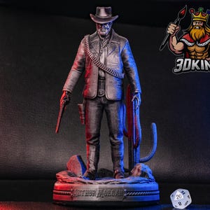 May include: A 3D printed figurine of Arthur Morgan from the video game Red Dead Redemption 2. The figurine is posed with a gun in his hand and is standing on a base with the words "Arthur Morgan" inscribed on it. The figurine is painted in a silver and black color scheme.