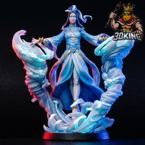 May include: A detailed figurine of a woman in a flowing blue gown, surrounded by stylized water elements. The figure has long white hair and is adorned with gold accents. The base is dark, and the overall design suggests a fantasy theme.