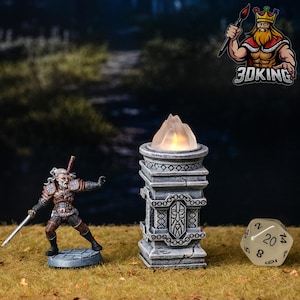 Può includere: Una miniatura dipinta di un guerriero che impugna una spada, una colonna con texture in pietra con una fiamma luminosa sulla sommità e un dado a venti facce. La colonna presenta intricati motivi intagliati e un volto centrale.