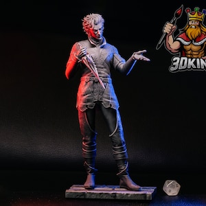 Könnte beinhalten: Graue Figur einer Person, die einen Dolch hält, mit aufwendigen Details an der Kleidung und einer dramatischen Pose. Die Figur steht auf einer kleinen Plattform. Das 3DKING-Logo befindet sich oben rechts.