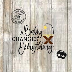 May include: A black and white graphic design with the text "A Baby Changes Everything" and a star with a curved line coming from it. The graphic also includes a brown and white design with an "X" in the center.