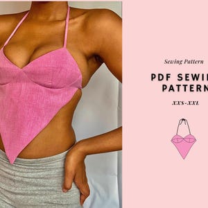 May include: A pink halter top with a unique asymmetrical design. The top is made of a textured fabric and features a triangular shape. The image also includes the text "PDF SEWING PATTERN" and size range "XXS-XXL".