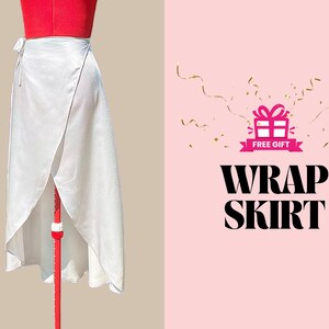 May include: A white wrap skirt with a tie closure. The skirt is on a mannequin and the background is pink with gold confetti and the text "FREE GIFT" and "WRAP SKIRT".