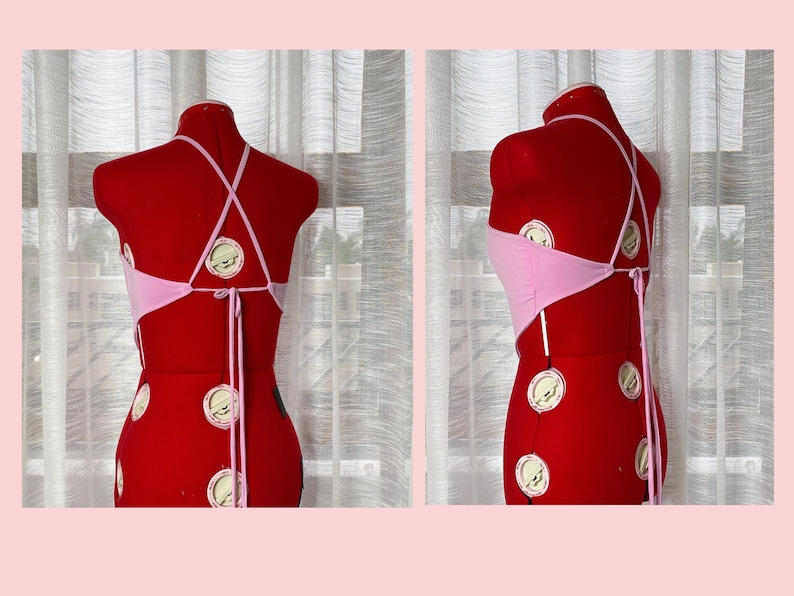 May include: A pink halter top with a criss-cross back and tie closure. The top is displayed on a red mannequin.