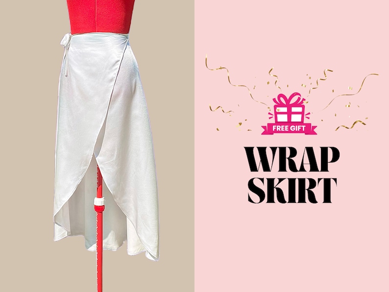 May include: White wrap skirt with a long, flowing design. The skirt is tied at the waist and has a slit in the front. The skirt is on a mannequin against a beige background. The text "FREE GIFT" and "WRAP SKIRT" is on a pink background with gold confetti.