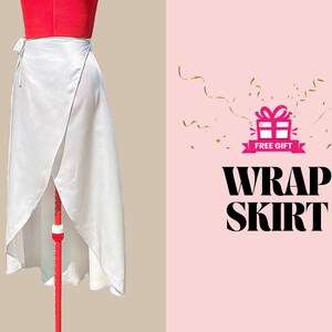 Puede incluir: Una falda envolvente blanca de tejido sedoso. La falda se muestra en un maniqu&iacute; rojo. La imagen tambi&eacute;n incluye el texto "FREE GIFT" y "WRAP SKIRT" sobre un fondo rosa.