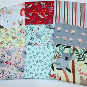 May include: A collection of patterned fabric squares. Designs include floral, koala, and striped patterns in various colors like red, blue, and pink. Some squares feature text and animal illustrations, suitable for crafting and sewing projects.