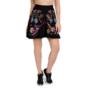 May include: Black skater skirt with a colorful floral and bird design. The skirt has a wide waistband and a flared silhouette.