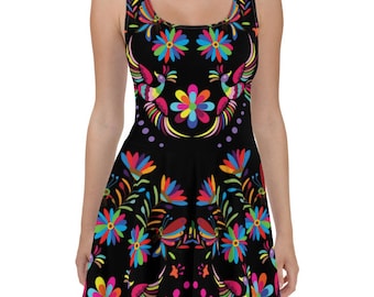 May include: A black skater dress with a colorful floral and bird print. The print features bright colors like pink, yellow, blue, green, and red.