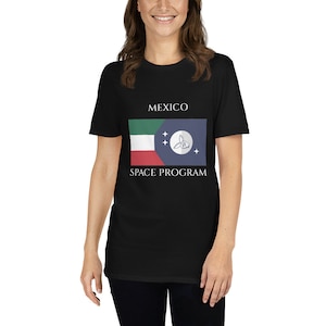 Könnte beinhalten: Schwarzes T-Shirt mit einer weißen Grafik der mexikanischen Raumfahrtflagge. Die Flagge zeigt einen grünen, weißen und roten horizontalen Streifen mit einem blauen Kreis, der ein stilisiertes Kaninchen und drei weiße Sterne enthält. Der Text "MEXICO SPACE PROGRAM" ist unter der Flagge gedruckt.