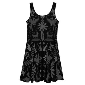 Puede incluir: Un vestido negro sin mangas con estampado floral y animal gris. El estampado presenta pájaros, flores y ciervos estilizados.