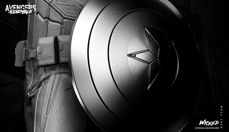 May include: Black and white image of a Captain America shield with a star emblem. The shield is metallic and has concentric circles. The image also shows a portion of a costume and utility belt. The text "AVENGERS ASSEMBLE" is visible.
