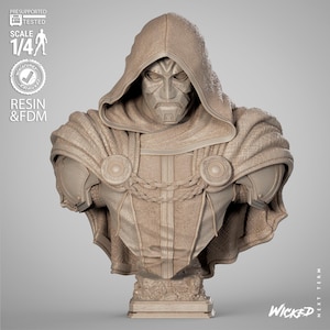 May include: A detailed bust of a character with a metallic mask and hooded cloak. The sculpture is in a neutral color, with intricate details on the face, armor, and cloak. The bust is labeled "Scale 1/4" and "Resin & FDM".