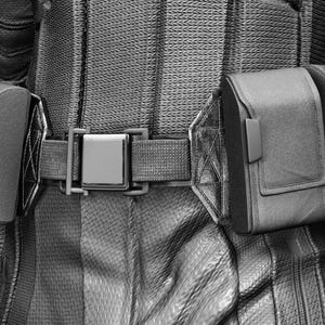 May include: Black and white image of a costume belt with pouches and a metallic buckle. The belt is part of a detailed outfit, with the text "AVENGERS ASSEMBLE" in the upper left corner. The image has a dark, dramatic aesthetic.