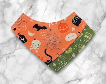 Peut inclure: Un bandana pour animaux de compagnie sur le thème d'Halloween avec un devant orange et un dos vert. Le côté orange présente une toile d'araignée, des chauves-souris, des citrouilles et des crânes. Le côté vert a des fioles de potion et des étoiles.