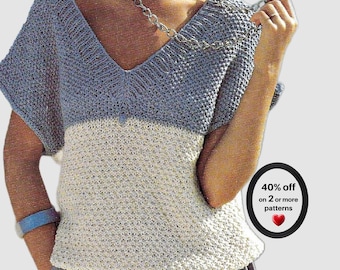 May include: A two-toned knit top featuring a V-neckline with short sleeves. The upper portion is slate blue, while the lower section is cream. A circular graphic on the right side displays the text 40% off on 2 or more patterns with a red heart.
